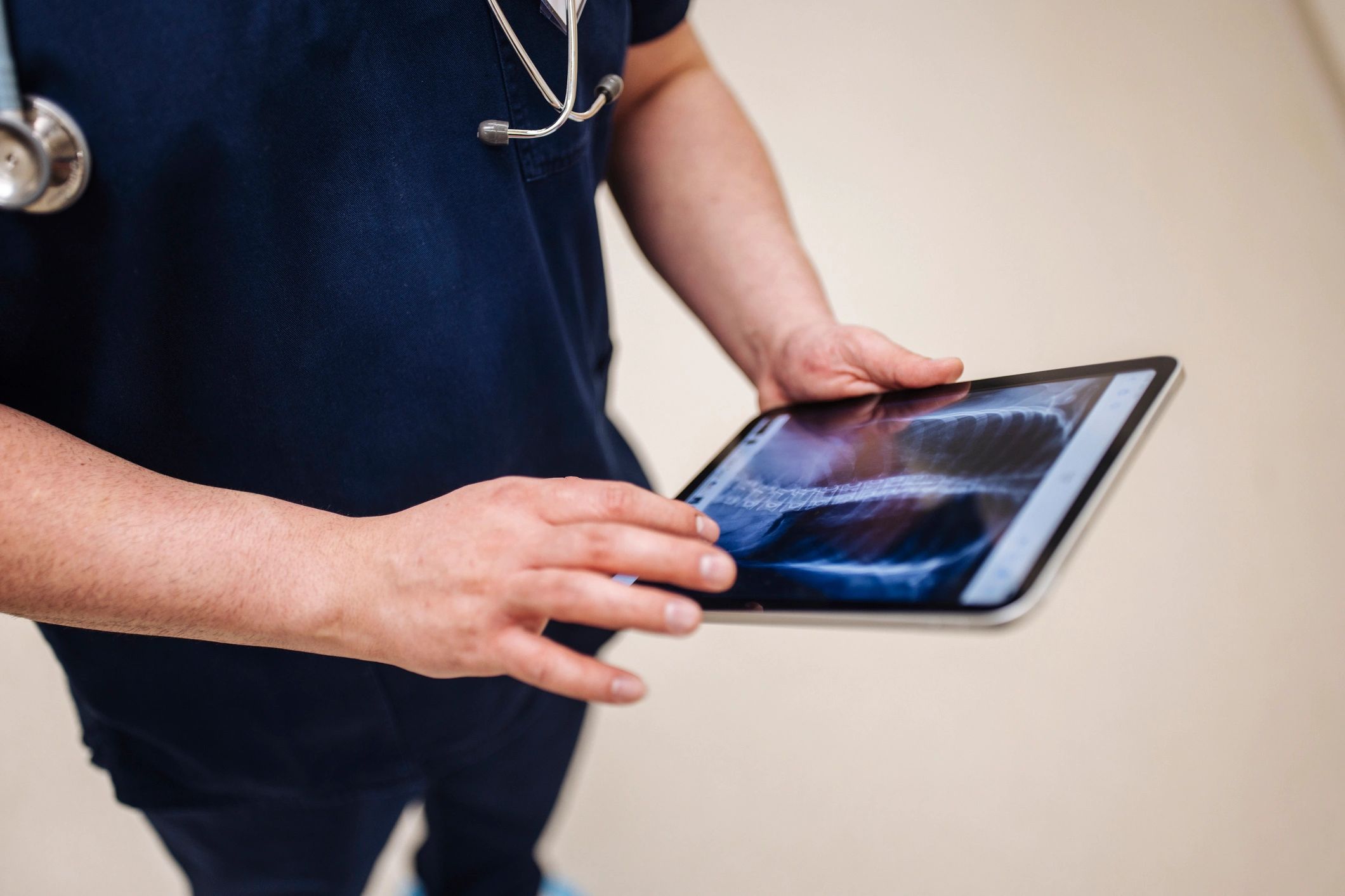 Healthcare professional reviewing medical data on a tablet